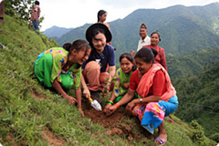 急な斜面に村人とボランティアがともに苗を植える